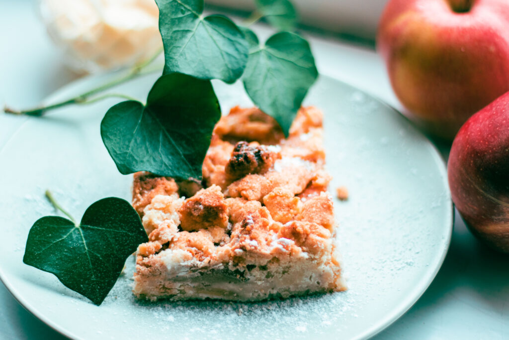 applepie with ivyleafs and blurry apples and vanillasauce behind